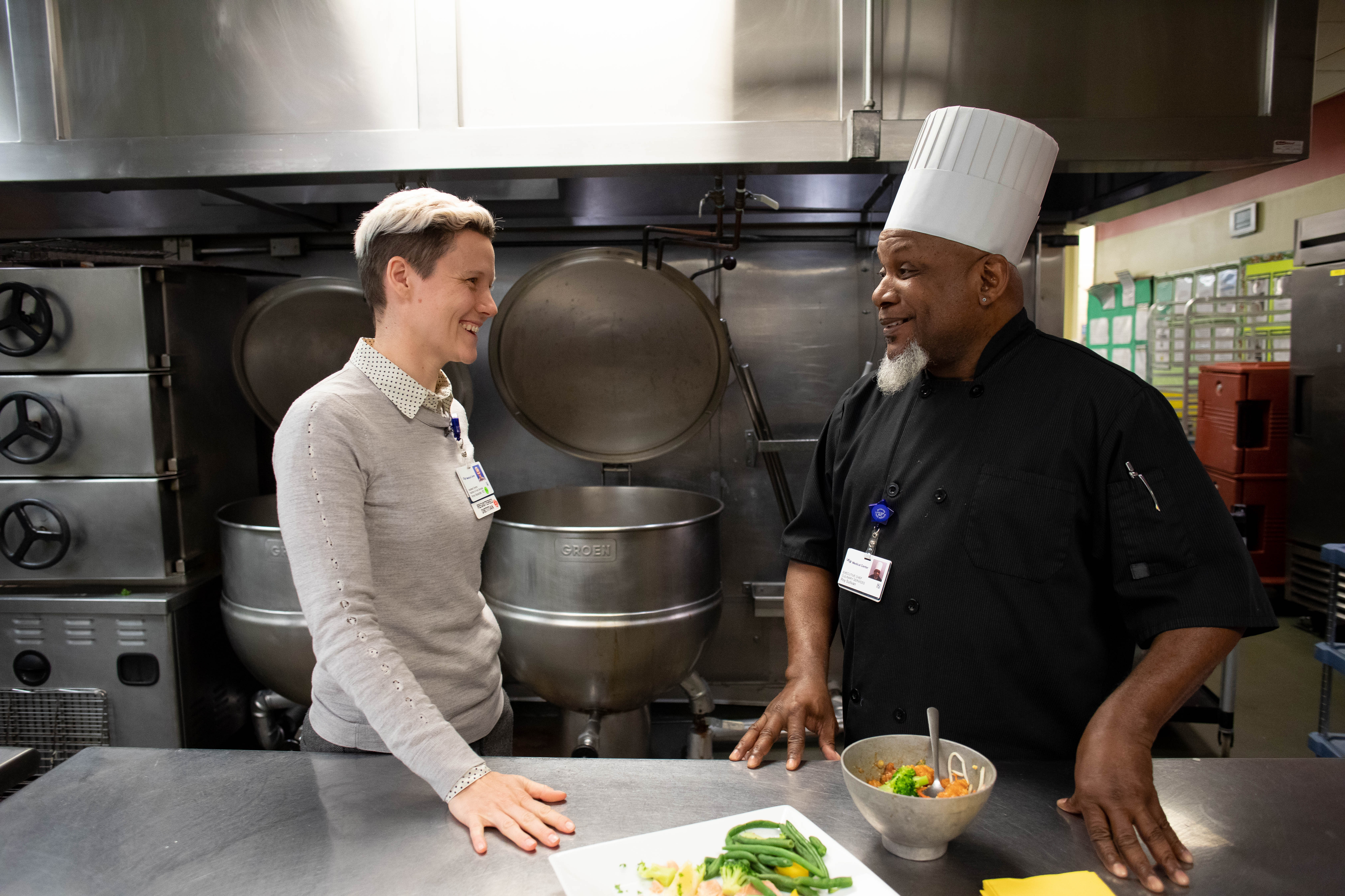 Nutrition and Food Services employees talking in a kitchen